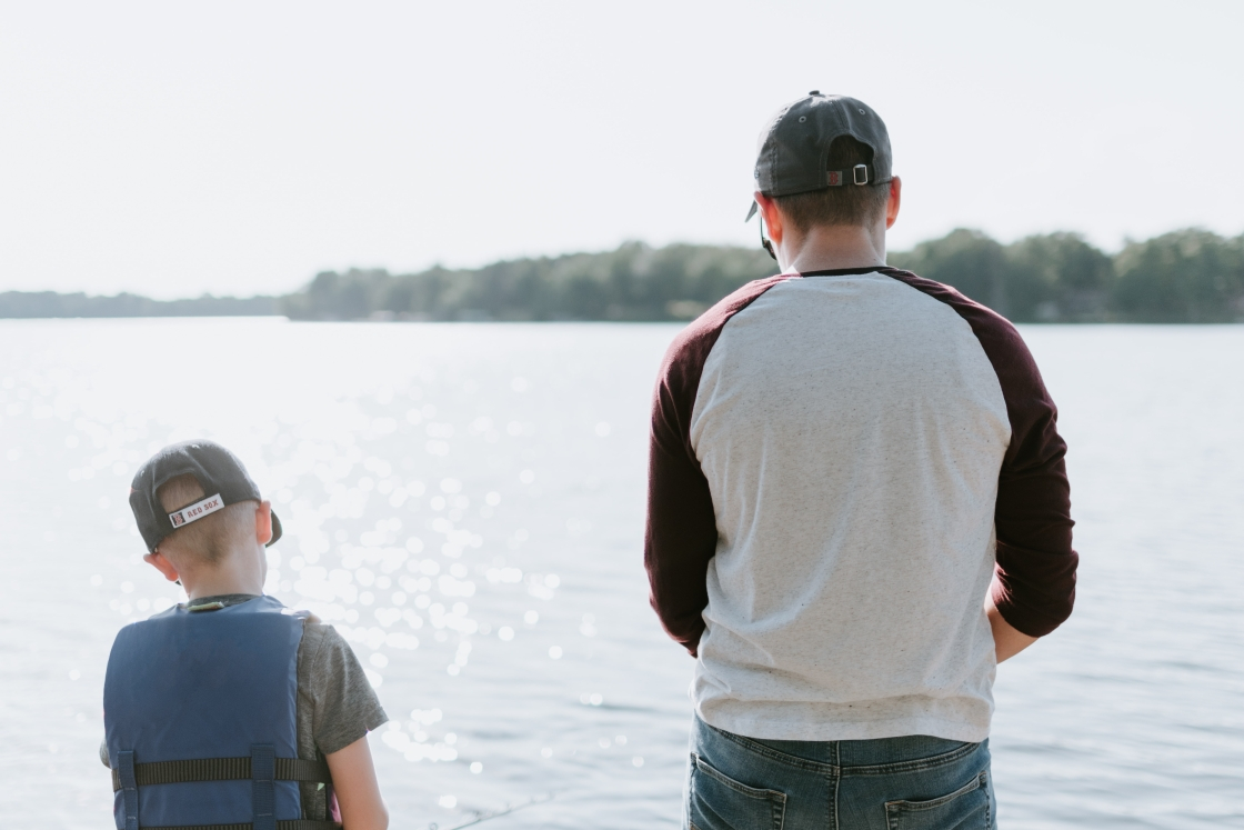 A father and son fishing on a lake